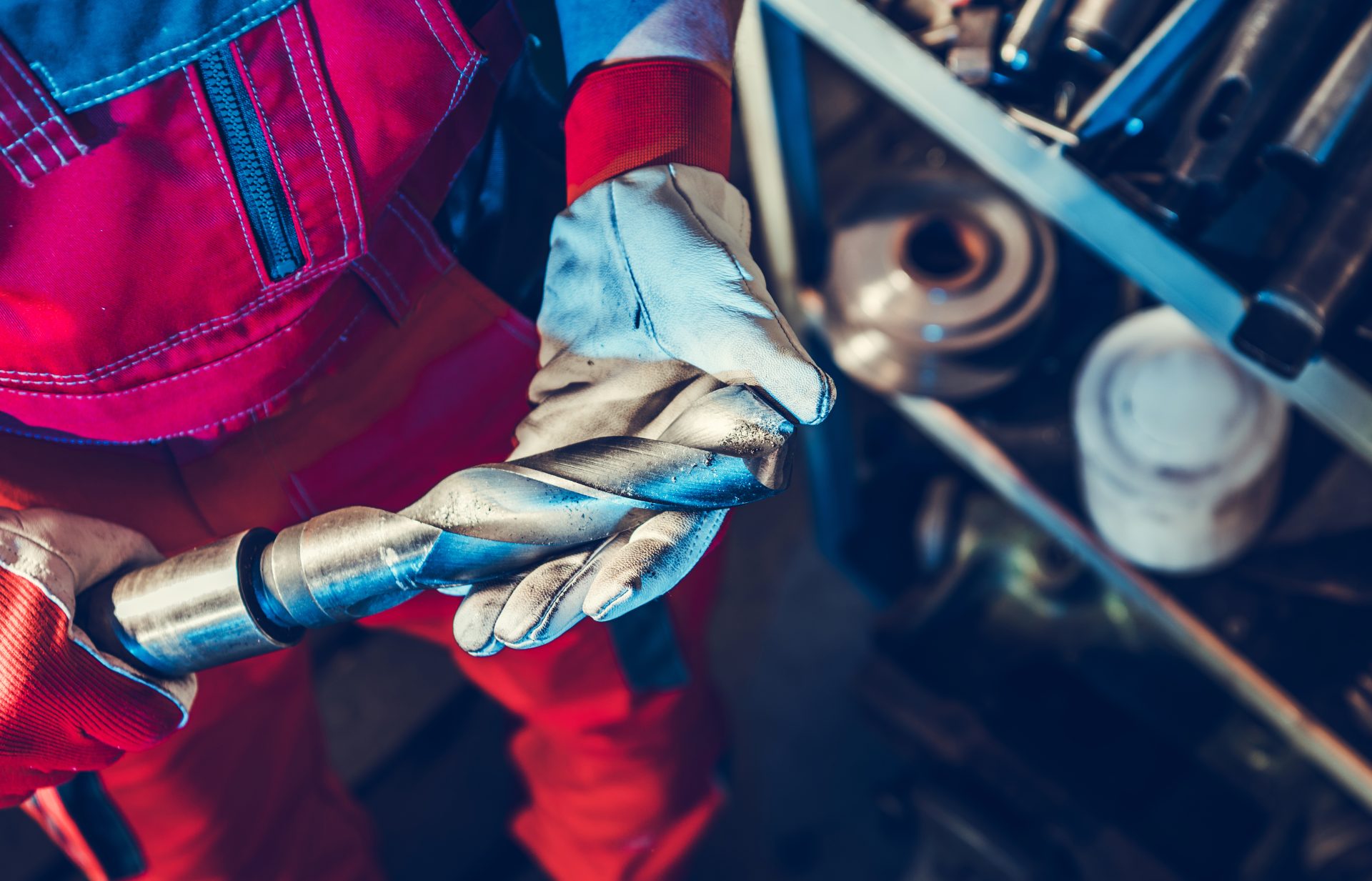 metalworking technician with large drill bit in his hands